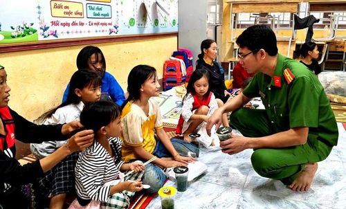 Công an trao tận tay suất cơm nóng đến các em nhỏ ở nơi tránh trú lũ quét. Ảnh: CTV