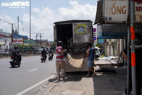 Dưới cái nắng giữa tháng 7, nhiều gia đình tất bật tháo dỡ mái tôn, cửa sắt, vật liệu xây dựng để vận chuyển đến nơi ở mới hoặc tận dụng cho công trình khác.