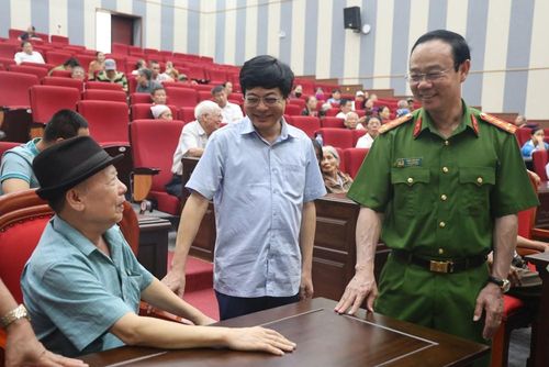 Đại tá Thân Văn Duy, Phó Giám đốc Công an tỉnh Bắc Ninh trao đổi với thân nhân liệt sĩ tại điểm thu nhận mẫu ADN trên địa bàn phường Quế Võ