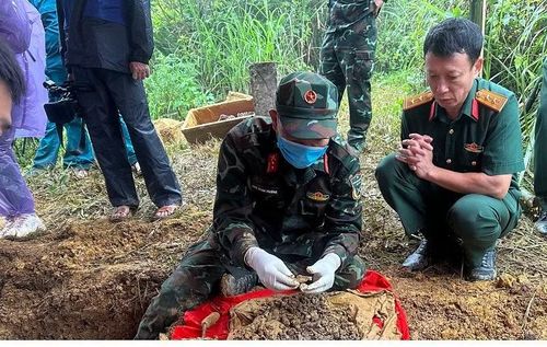 Trung tá Nguyễn Ngọc Toan ngồi lặng lẽ dõi theo cất bốc hài cốt 2 liệt sĩ.