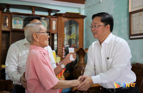 Chủ tịch Ủy ban MTTQ Việt Nam thành phố Lê Trí Thanh (bên phải) thăm ông Lê Tú (phường Bàn Thạch).