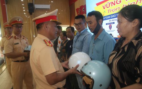Đại tá Phan Thanh Hồng, Trưởng Phòng CSGT Công an TP Đà Nẵng trao tặng mũ bảo hiểm đạt chuẩn cho người dân tham gia chương trình "Vững tay lái - Trọn bình an". (Ảnh: Phương Kiếm)