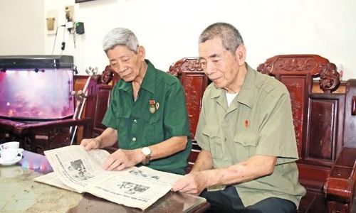 Thương binh Vũ Huy Chính (bên trái) và thương binh Vũ Huy Tông cùng đọc báo, trò chuyện về những đổi thay của quê hương, đất nước.