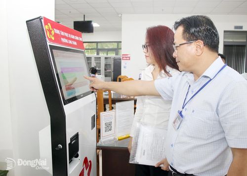 Chuyên viên Trung tâm Phục vụ hành chính công phường Long Thành (thành phố Đồng Nai) hỗ trợ người dân đăng ký thực hiện thủ tục hành chính trực tuyến.