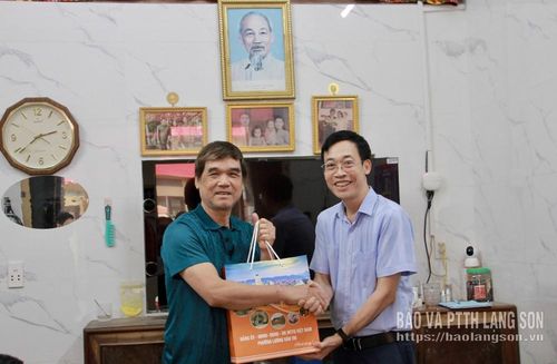 Đồng chí Hoàng Xuân Đồng, Bí thư Đảng ủy, Chủ tịch HĐND phường Lương Văn Tri, trưởng đoàn công tác (bìa phải) tặng quà ông Đặng Đình Hợp (khối Cửa Bắc)