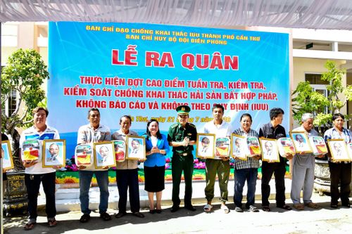 Phó Giám Đốc Sở Nông nghiệp và Môi trường Quách Thị Thanh Bình và Chính ủy BĐBP TP. Cần Thơ Đại tá Huỳnh Thanh Hùng tặng Cờ Tổ quốc, ảnh Bác Hồ, tủ thuốc Biên phòng cho các ngư dân. Ảnh: Văn Long