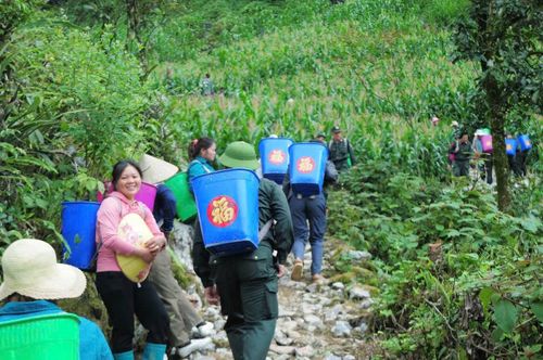 Cán bộ, chiến sĩ Tiểu đoàn 4, Trung đoàn Cảnh sát cơ động số 2, Bộ Tư lệnh Cảnh sát cơ động gùi vật liệu vượt địa hình khó khăn để thi công công trình "Con đường Đoàn kết"