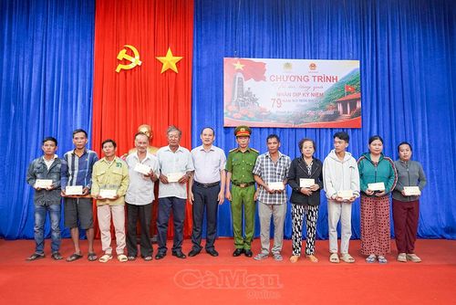 Chủ tịch UBND xã Khánh An Nguyễn Thanh Liêm và Thượng tá Phan Mộng Hải trao quà cho gia đình chính sách.