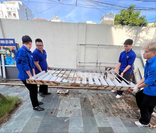 Di chuyển một số đồ vật cũ, làm sạch khuôn viên nhà truyền thống cách mạng. Ảnh: PT