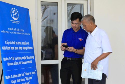 Đoàn viên thanh niên xã Mê Linh hướng dẫn người cao tuổi thực hiện thủ tục hành chính online. Ảnh Phạm Hùng