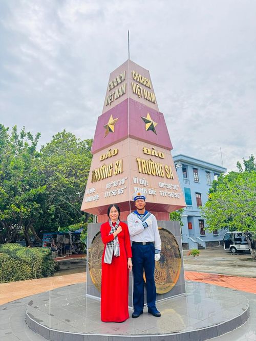 Bác sĩ Hương và người lính trẻ chụp ảnh kỷ niệm tại cột mốc chủ quyền đảo Trường Sa. Ảnh: CTV