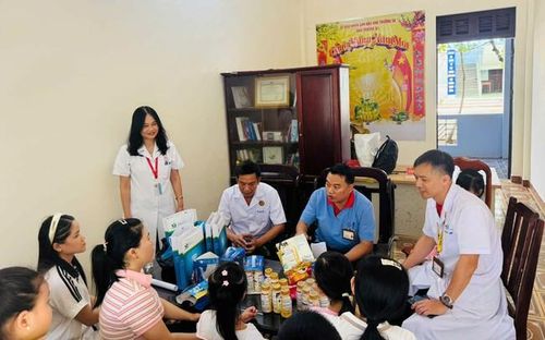 BS CK1. Nguyễn Trường Xuân (áo trắng ngồi bên trong) - Trung tâm Y tế Trường Sa cùng đoàn công tác Bộ Y tế khám các bệnh ngoài da và tư vấn dinh dưỡng cho các bà mẹ và trẻ em đảo Trường Sa lớn. Ảnh: CTV