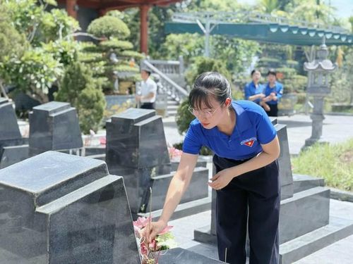Một đoàn viên thanh niên đang sửa sang, dâng hương tại phần mộ các anh hùng liệt sĩ. Ảnh: TĐHT.