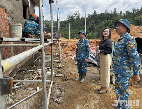  Cô giáo Hồ Thị Tâm, Hiệu trưởng Trường nội trú liên cấp xã Tây Giang cùng lực lượng xây dựng của Sư đoàn Phòng không 375 tại công trình. 