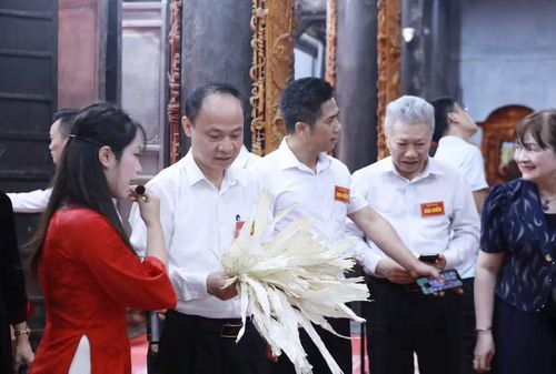 Các đại biểu tham quan, trải nghiệm tại lớp học truyền nghề làm nón làng Chuông ngay tại Đình làng. Ảnh: Đình Tuệ.