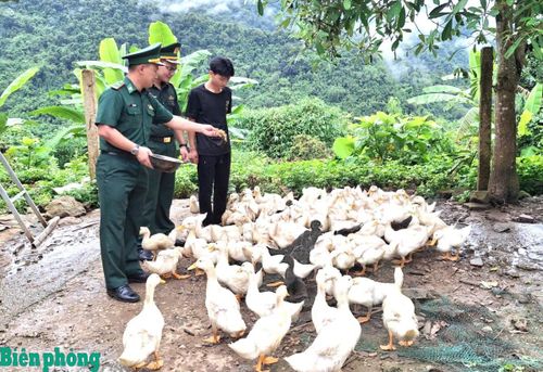 Cán bộ Đồn Biên phòng Mù Cả hướng dẫn nhân dân chăm sóc gia cầm. Ảnh: Đức Duẩn