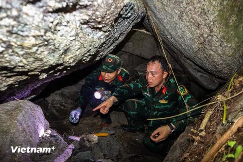 Lực lượng tìm kiếm phải chui vào những hốc sâu chật hẹp, len lỏi qua các khối đá khổng lồ xếp chồng lên nhau. (Ảnh: Thanh Phong - Quang Cường/Vietnam+)