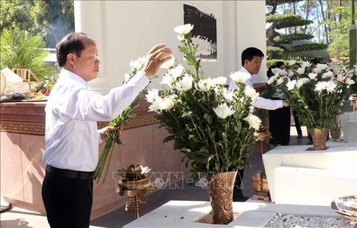 Du khách dâng hoa tại khu mộ 10 nữ liệt sĩ Thanh niên xung phong Ngã ba Đồng Lộc. Ảnh: Công Tường/TTXVN