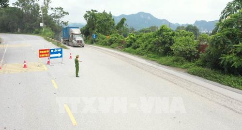 Công an phường Tam Chúc hướng dẫn các phương tiện chuyển hướng di chuyển qua đoạn đường song hành Quốc lộ 21A nhằm đảm bảo an toàn. Ảnh: Hải Yến - TTXVN 