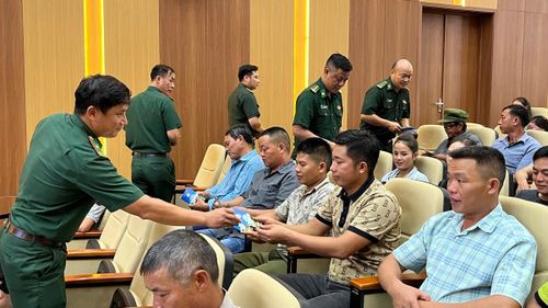 Bộ đội biên phòng phát tờ rơi tuyên truyền đến người dân tham gia chương trình truyền thông.