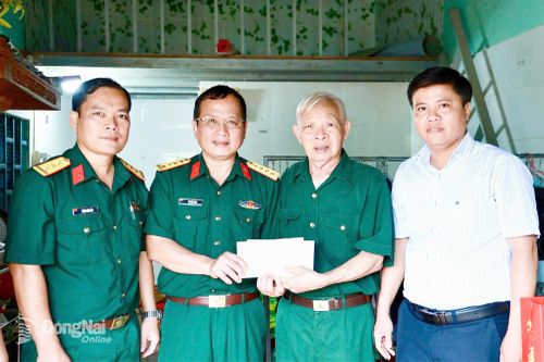 Đại tá Vũ Văn Định, Phó chủ nhiệm Chính trị Binh đoàn 16, trao quà tri ân ông Phạm Thanh Tường, người hoạt động kháng chiến bị nhiễm chất độc hóa học tại ấp Cầu 2, xã Đồng Tâm.