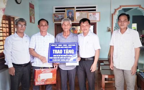  Ông Nguyễn Xuân Tú - Bí thư Đảng ủy phường Hoài Nhơn Nam (thứ 2 từ phải sang) trao hỗ trợ kinh phí sửa chữa nhà cho thương binh Đinh Xuân Tôi (khu phố Hoài Xuân). Ảnh: ĐVCC 