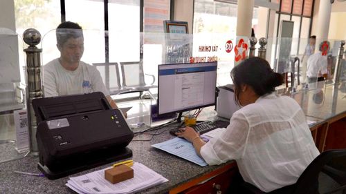 Anh Nguyễn Minh Phi được cán bộ Trung tâm hành chính công hỗ trợ hoàn tất thủ tục đăng ký kinh doanh.