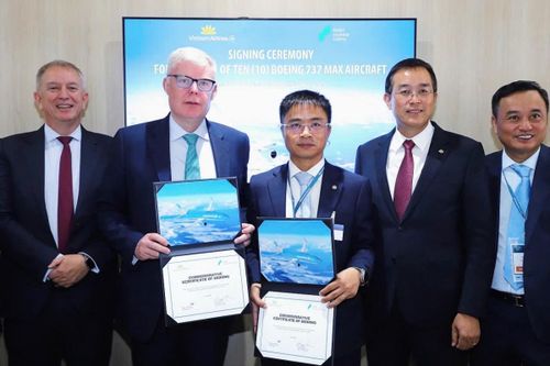 Ông Nguyễn Chiến Thắng, PTGĐ Vietnam Airlines và ông Barry Flannery, Giám đốc Thương mại SMBC Aviation Capital trao biên bản thỏa thuận dưới sự chứng kiến của lãnh đạo cấp cao hai bên. Ảnh: VNA