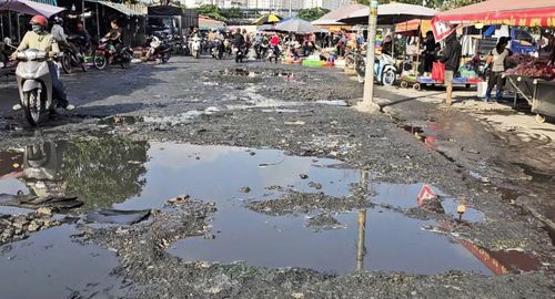 Đoạn đường đầy ổ gà, đọng nước hôi thối ở chợ tự phát vào sáng ngày 22/7/2026.