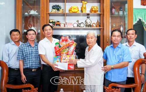 Đồng chí Nguyễn Bình Tân cùng đoàn công tác trao phần quà đến ông Nguyễn Văn Hốt.