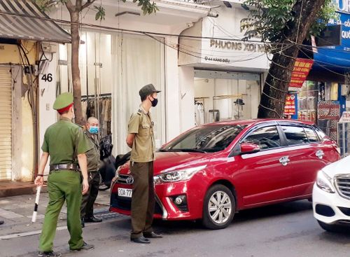 Lực lượng chức năng xử lý phương tiện vi phạm dừng đỗ trái quy định. Ảnh: N.Lộc