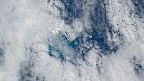 Ảnh màu tự nhiên từ vệ tinh Landsat 9 chụp ngày 11/5 cho thấy các cột khói núi lửa dày đặc bốc lên từ nền núi lửa dưới biển đang hình thành, được bao quanh bởi mây. (Ảnh: NASA)