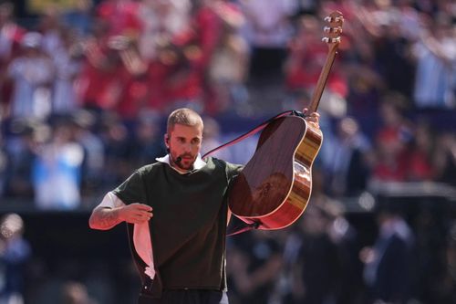 Justin Bieber vừa ôm guitar vừa trình bày phiên bản acoustic của “Everything Hallelujah”. (Ảnh: AP)