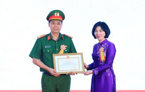 Chủ tịch HĐND thành phố Hà Nội Phùng Thị Hồng Hà trao Bằng khen của UBND thành phố tặng Thượng tá Phạm Văn Trọng, Trưởng Công an phường Hà Đông. Ảnh: Quang Thái