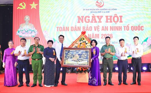 Chủ tịch HĐND thành phố Hà Nội Phùng Thị Hồng Hà tặng quà và hoa chúc mừng phường Hà Đông. Ảnh: Quang Thái