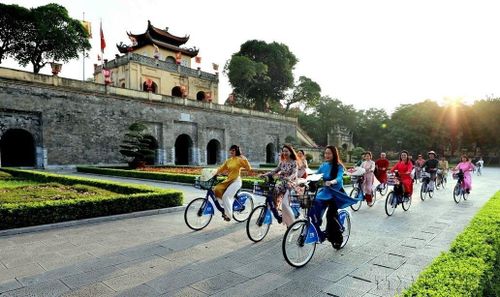  Phụ nữ Thủ đô trong trang phục áo dài đạp xe qua các điểm di sản của Hà Nội. Ảnh: Nhật Anh – TTXVN 