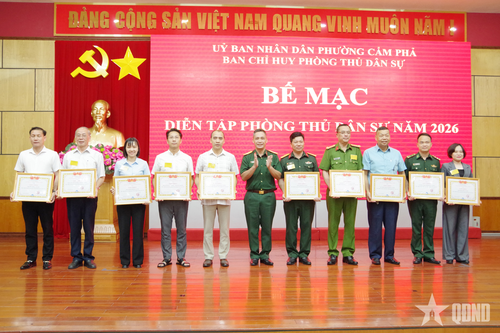  Đại tá Nguyễn Ngọc Sơn, Phó chỉ huy trưởng Bộ CHQS tỉnh Quảng Ninh (đứng giữa) trao thưởng cho các tập thể có thành tích xuất sắc trong diễn tập phòng thủ dân sự phường Cẩm Phả năm 2026. 