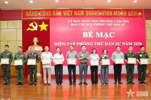 Đồng chí Phạm Lê Hưng, Bí thư Đảng ủy, Chủ tịch HĐND phường Cẩm Phả (thứ 6, từ phải sang) trao Giấy khen cho các cá nhân có thành tích xuất sắc trong diễn tập phòng thủ dân sự phường Cẩm Phả năm 2026.