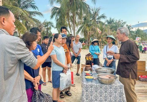  Du khách tìm hiểu quy trình làm mắm truyền thống qua những chia sẻ của ngư dân địa phương. Ảnh: XUÂN QUỲNH 
