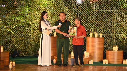  Thiếu tướng Nguyễn Thành Trung, Chính ủy Bộ Tư lệnh TPHCM trao di ảnh đến thân nhân liệt sĩ. Ảnh: MẠNH THẮNG 