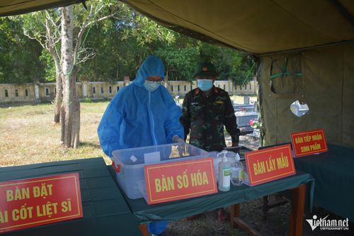 Giữa cái nắng gần 40 độ C, nhân viên y tế mặc đồ bảo hộ lấy mẫu hài cốt đủ điều kiện phục vụ giám định ADN. Ảnh: Lê Bằng