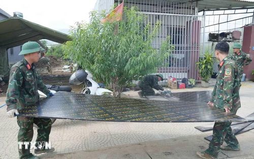 Bộ đội làm việc xuyên ngày đêm để xây nhà cho người dân Mường Than bị lũ quét. (Ảnh: Nguyễn Oanh/TTXVN)