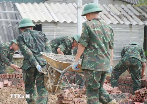 Bộ đội làm việc xuyên ngày đêm để xây nhà cho người dân Mường Than bị lũ quét vừa qua. (Ảnh: Nguyễn Oanh/TTXVN)