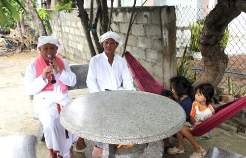 Ông Thông Long đang dạy thổi kèn Saranai cho con trai và các cháu nhỏ trong xóm làng. (Nguồn: Vietnam+)