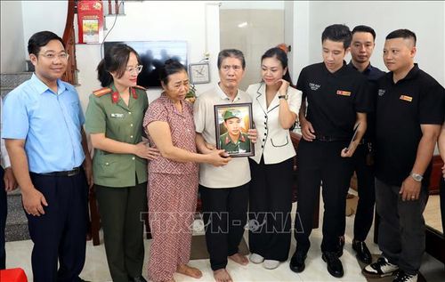 Gia đình ông Nguyễn Đình Vinh (thôn Trúc Đình, xã Xuân Trúc) xúc động khi nhận được di ảnh của liệt sĩ Nguyễn Đình Tịnh. Ảnh: Thế Duyệt/TTXVN