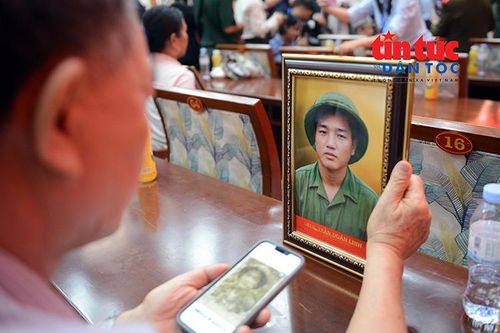 Ông Trần Doãn Bách không giấu được niềm xúc động khi xem ảnh anh trai được phục dựng từ bức ảnh cũ đã nhòe, chỉ còn vài đường nét mờ nhạt.