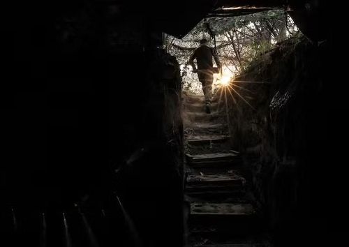 Một binh sĩ thuộc lữ đoàn của Krynitskyi đang đóng quân gần tiền tuyến, cầm theo một quả đạn pháo để bắn vào lực lượng địch. Ảnh: Reuters.