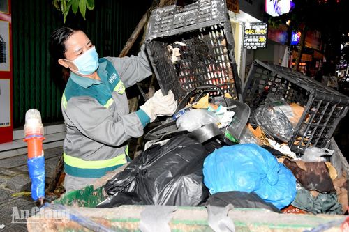 Bà Nguyễn Thị Chín thu gom rác. Ảnh: KIỀU DIỄM