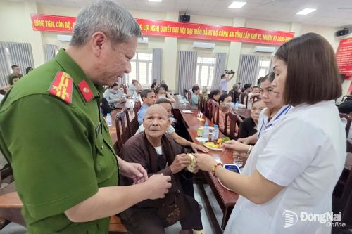 Lãnh đạo Công an phường Bình Phước và nhân viên y tế thăm hỏi các thân nhân liệt sĩ. Ảnh: Trần Danh