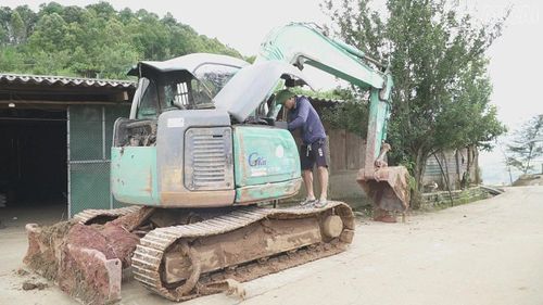 Anh Giàng A Sình, ở thôn Lao Chải, tranh thủ sửa máy xúc sau ba ngày tham gia thông đường vào thôn Dào Cu Nha.